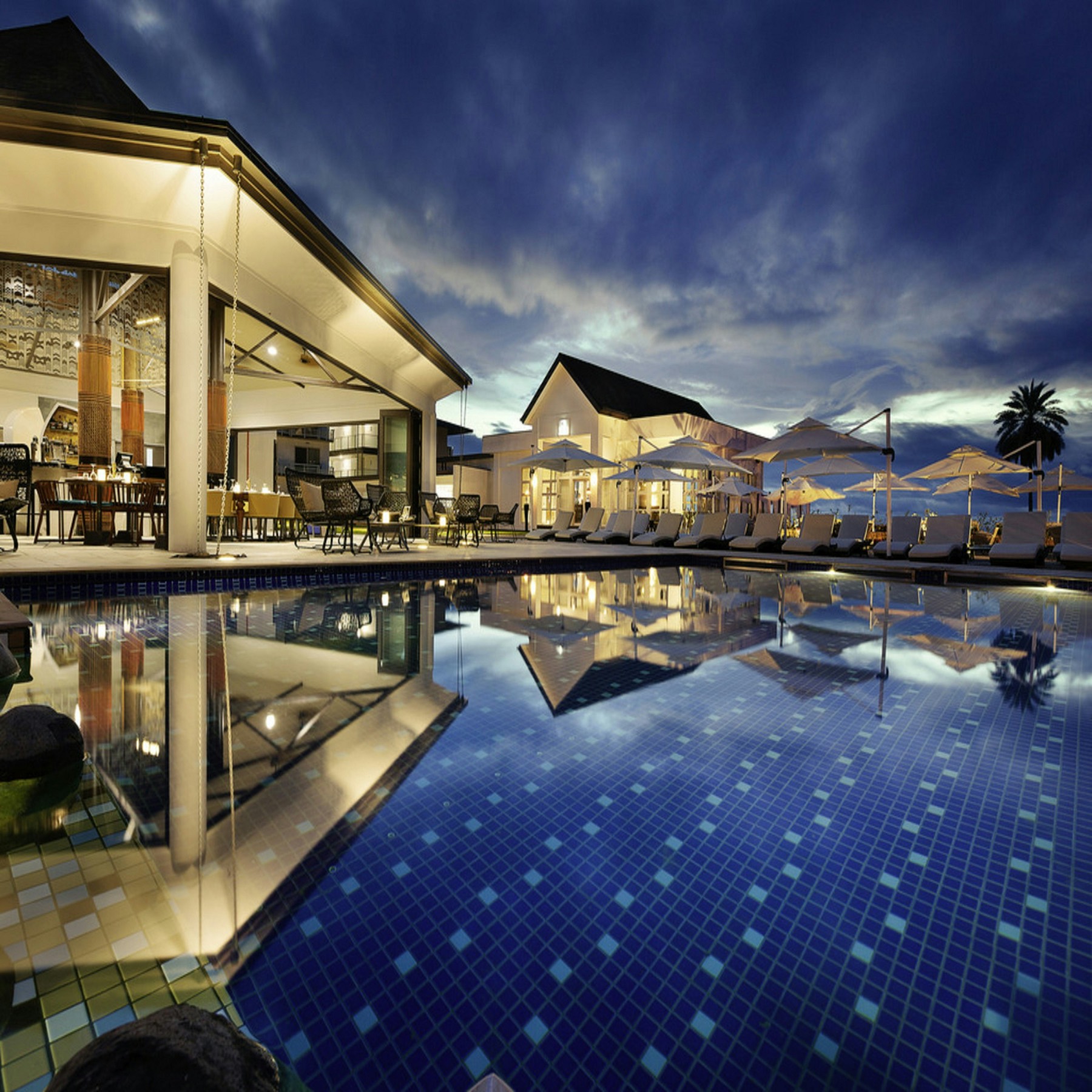 A hotel terrace and pool at dusk